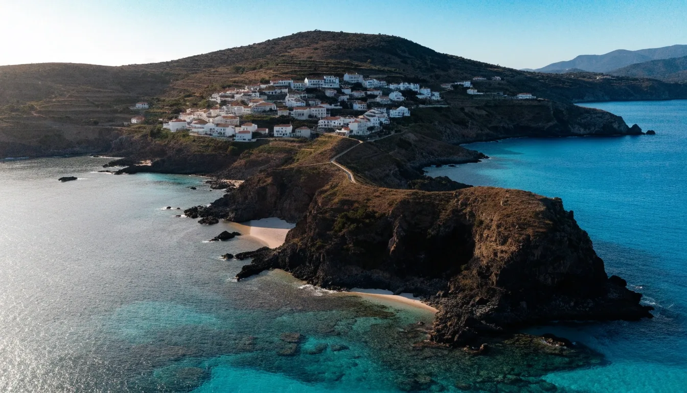 Costa mediterránea de una isla española vista desde el aire con casas y laderas escalonadas