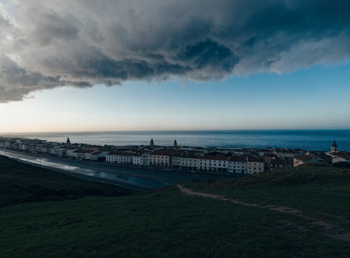 Amanecer frío sobre una ciudad costera española, con un frente de nubes entrando por el noroeste