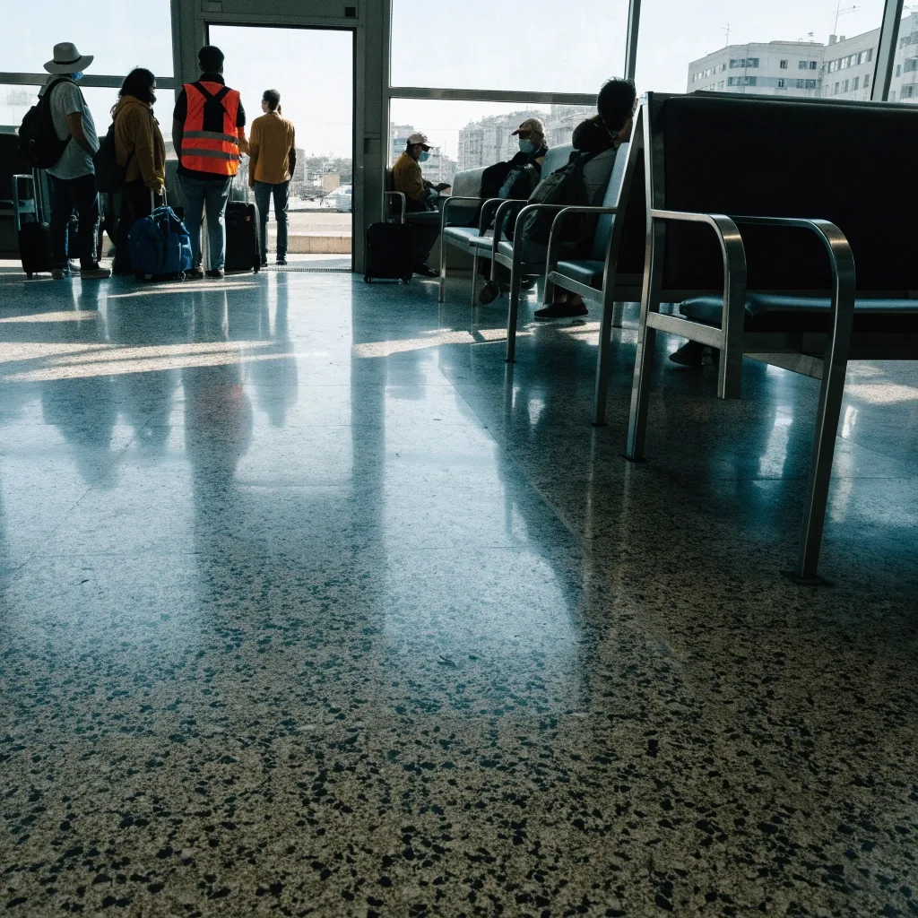 Andén de una estación regional española con viajeros y equipaje camino de un tren de salida